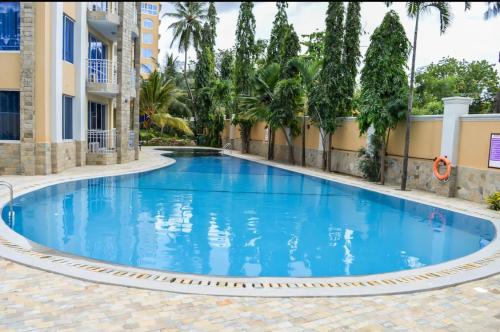 a swimming pool in a resort with blue water at Beachfront Bliss Apartment in Mombasa