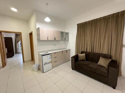 a living room with a couch and a kitchen at دبليو تاون للشقق المخدومة - W Town Serviced Apartments in Jeddah