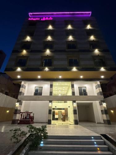 a tall building with purple lights on top of it at دبليو تاون للشقق المخدومة - W Town Serviced Apartments in Jeddah