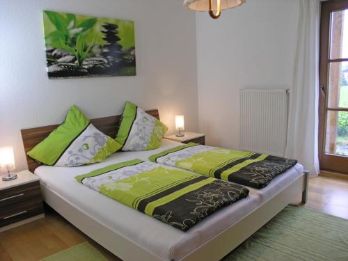 a bedroom with two beds with green and yellow sheets at Ferienwohnung Anderl in Gstadt am Chiemsee