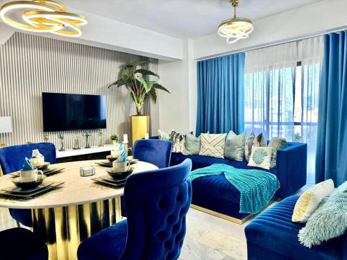 a living room with a blue couch and a table at Wendy Luxury Tower in Santiago de los Caballeros