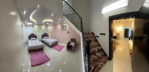 a view of a room with two beds and a mirror at شقه in Hail