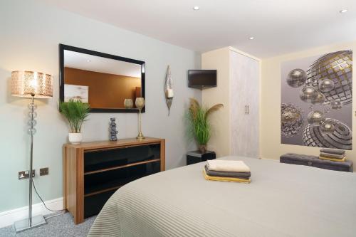 1 dormitorio con cama y espejo grande en Dennison House en Londres