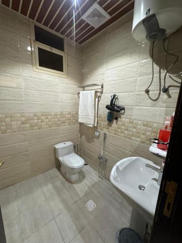a bathroom with a toilet and a sink at شقه in Hail