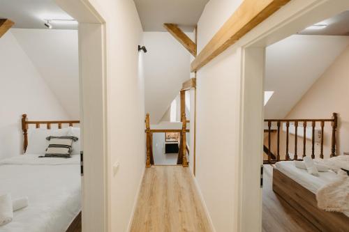 a attic bedroom with two beds and a hallway at Holiday Agoston Apartments in Timişoara