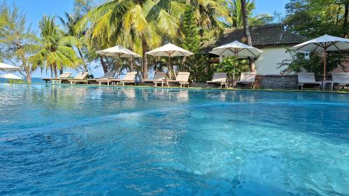 uma grande piscina com cadeiras e guarda-sóis em Ancarine Beach Resort em Phu Quoc