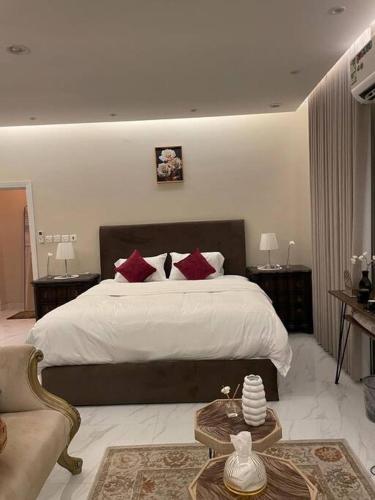 1 dormitorio con 1 cama grande con almohadas rojas en شالية خاص مع جناح فندقي en Ḩayy aş Şāliḩīyah