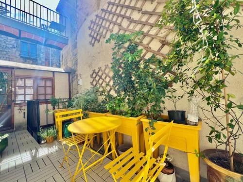 une table et des chaises jaunes sur une terrasse dans l'établissement Au Croco fleuri, 50m des arènes, terrasse, à Nîmes