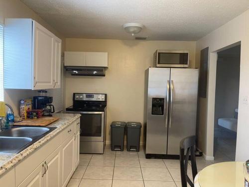 a kitchen with a stainless steel refrigerator and appliances at Private Queen Bedroom B house shared common spaces in Fort Pierce