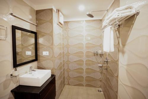 ein Bad mit einem Waschbecken und einer Dusche in der Unterkunft Regenta Resort Madhuganga Ukhimath in Ukhimath
