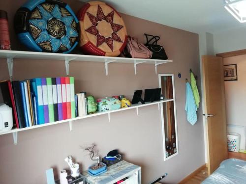 a room with shelves with plates and books at Habitacion en piso compartido y wc compartido cerca de Playa de Samil in Vigo