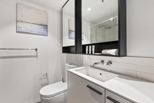 a white bathroom with a toilet and a sink at FLEMINGTON - Melbourne City Views in Melbourne