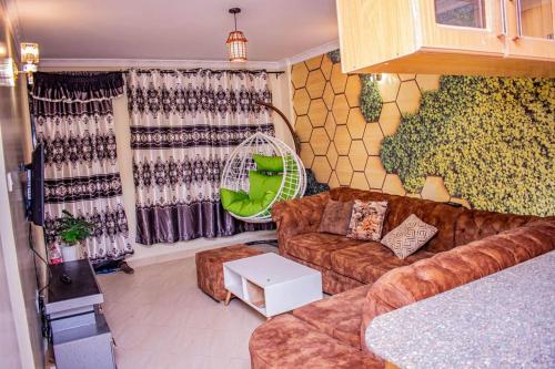 a living room with a couch and a table at Dandy Home, 2 BdRm, Estn Bypass Kamakis Greenspot in Ruiru