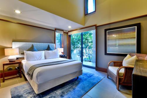 a bedroom with a large bed and a window at Yacht Club Villas on Hamilton Island by HIHA in Hamilton Island