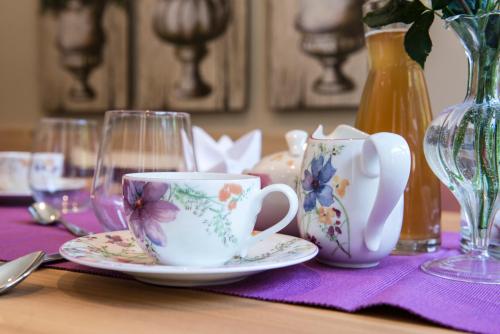 a table with two cups and plates on a table at Waldruhe - Bett, Frühstück & ein Lächeln in Bad Aussee