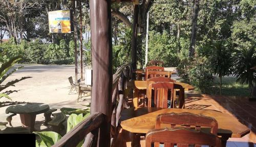 a group of wooden tables and chairs in a patio at Seaside Sanctuary Bungalows in Ko Lanta