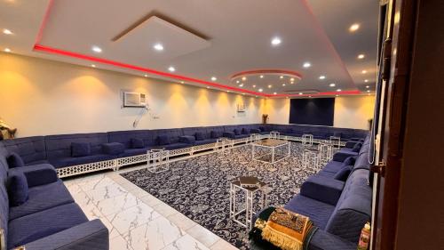 una sala de conferencias con sofás azules y un escenario en Thenoblejewel, en Al Laqīţah