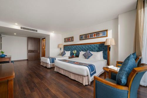 a hotel room with two beds and a couch at Balcona Hotel Da Nang in Da Nang