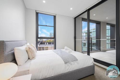 um quarto com uma cama e uma grande janela em Aircabin - Zetland - Lovely - 2 Beds Apt Free Park em Sydney
