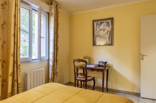een slaapkamer met een bureau en een stoel naast een raam bij Casa Sulana in Bastia