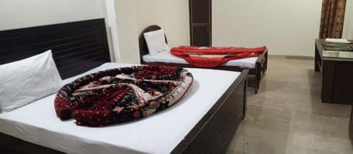 a room with two beds and a chair and a cake at Hotel Abbasi Palace in Rawalpindi