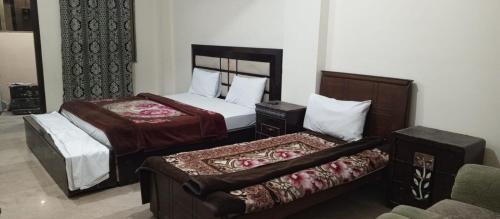 Hotel Abbasi Palace في روالبندي: غرفة فندقية بسريرين واريكة