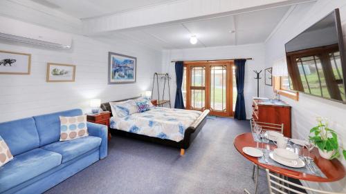 sala de estar con sofá azul y mesa en Sleepy Hollow Hideout - Hideout 1, en Forest