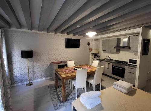 eine Küche mit einem Holztisch und weißen Stühlen in der Unterkunft Otto House Apartment in Venedig