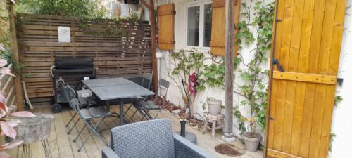 un patio avec une table et des chaises et une clôture dans l'établissement La Cabane de Didi, à Andernos-les-Bains