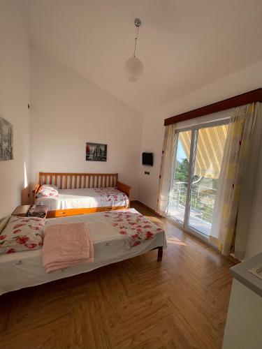 a bedroom with two beds and a large window at Garden Villa Sunny in Tale