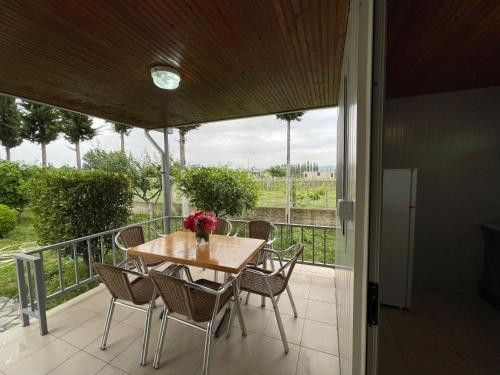 una mesa y sillas en un balcón con vistas a un campo en Garden Villa Sunny, en Tale