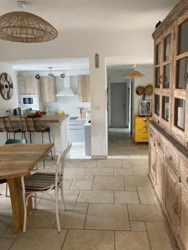 een keuken met een tafel en stoelen en een eetkamer bij L'Oasis, villa au calme, 400m plage à pied in Saint-Aygulf