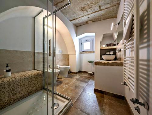 y baño con ducha de cristal y aseo. en Oikia Vacanze Giuggianello Le Bey, en Giuggianello