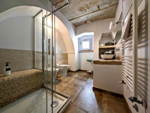 a bathroom with a glass shower and a toilet at Oikia Vacanze Giuggianello Le Bey in Giuggianello