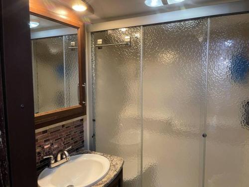 a bathroom with a sink and a glass shower at Entire 1bedroom RV Camper in Fort Pierce