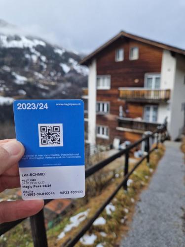 a person holding a security card in front of a house at Studio sans cuisine in Vissoie