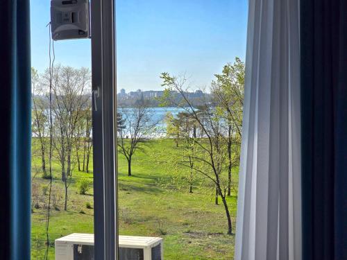 een raam met uitzicht op een veld en een meer bij Sky Studio in Constanţa