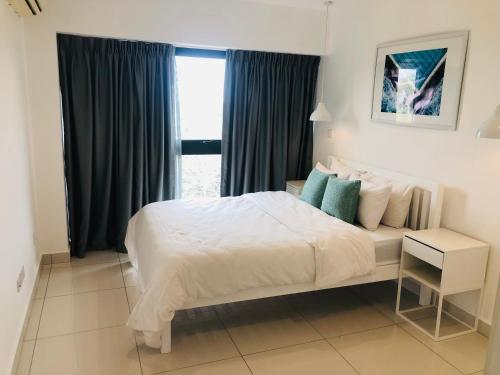 een slaapkamer met een groot bed en een raam bij Luxurious 2 Bedroom Apartment @Embassy Garden in Accra