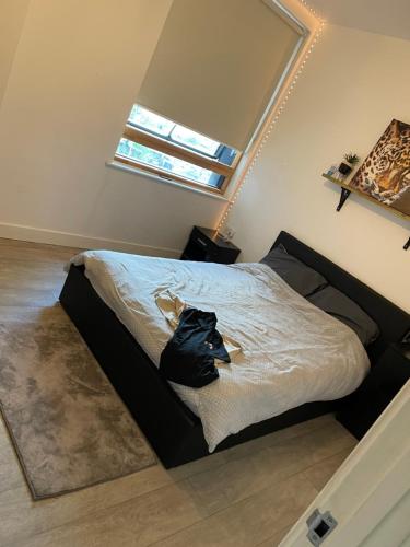 Enfield homes في لندن: غرفة نوم مع سرير مع حقيبة سوداء عليه