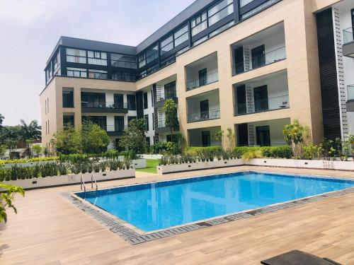 un immeuble d'appartements avec une piscine en face dans l'établissement Luxurious 2 Bedroom Apartment @Embassy Garden, à Accra