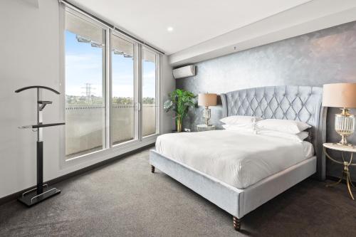 um quarto com uma cama grande e uma janela grande em Elegant 1-Bed by Riverside Park & Amenities em Sydney