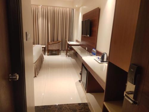 a hotel room with a bed and a bathroom at Hotel the Plaza in Hyderabad