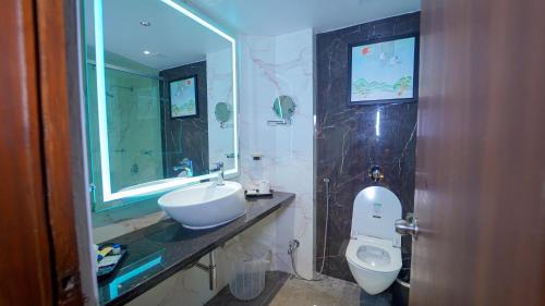 a bathroom with a sink and a toilet and a mirror at Hotel the Plaza in Hyderabad