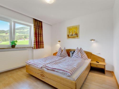 a bedroom with a bed with a large window at Upscale Apartment in Salzburg with terrace and country views in Hollersbach im Pinzgau