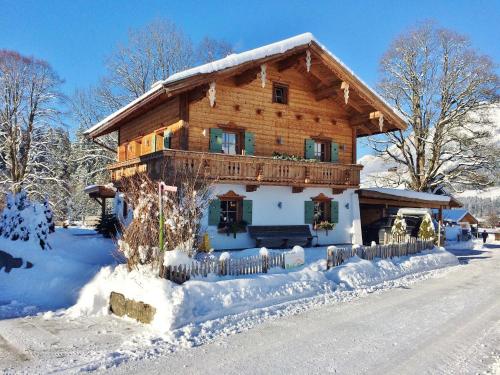 Casa de madera grande con nieve en el suelo en Detached holiday home in Ellmau near the ski lift, en Ellmau