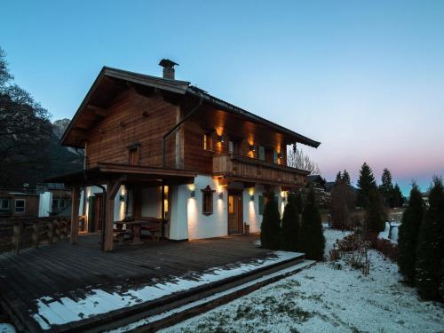a wooden house with a deck in the snow at Detached holiday home in Ellmau near the ski lift in Ellmau