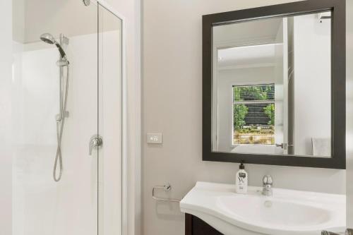 a white bathroom with a sink and a mirror at Valley Villa - Cardrona Holiday Home in Cardrona