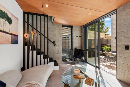a living room with a glass table at Divine on Derby - Christchurch Holiday Home in Christchurch