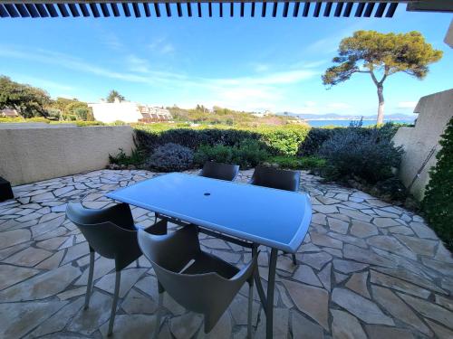 une table bleue et des chaises sur une terrasse en pierre dans l'établissement Le Serenity : mer, calme et tranquillité, à Saint-Aygulf