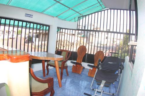 a room with a table and chairs and windows at The Island Home in Puerto Ayora